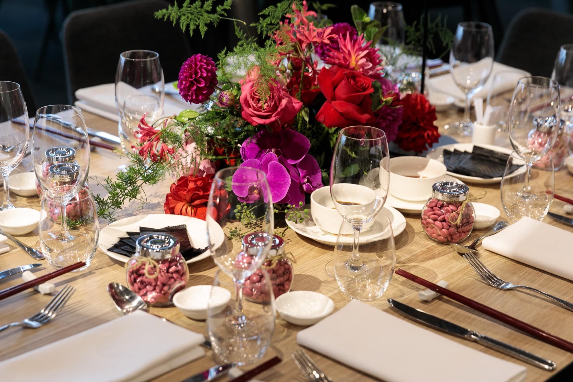 A Crystal Palace banquet table set with flowers, chopsticks and fine glassware